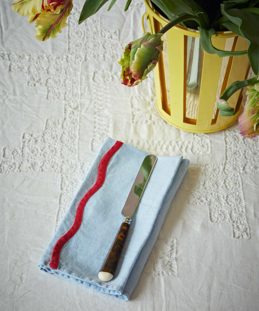 a blue linen napkin with red scalloped trim