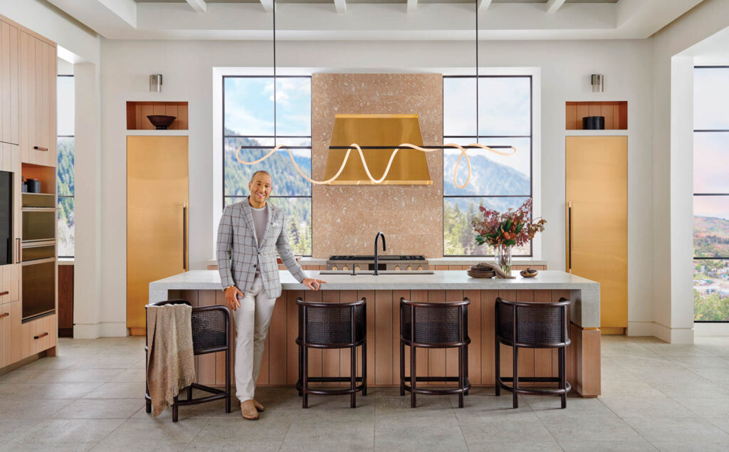 a man in a gray suit standing near a kitchen island