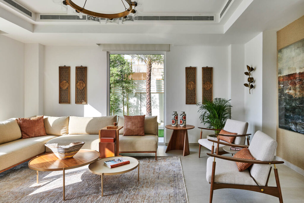 a living room with neutral furnishings and a round chandelier