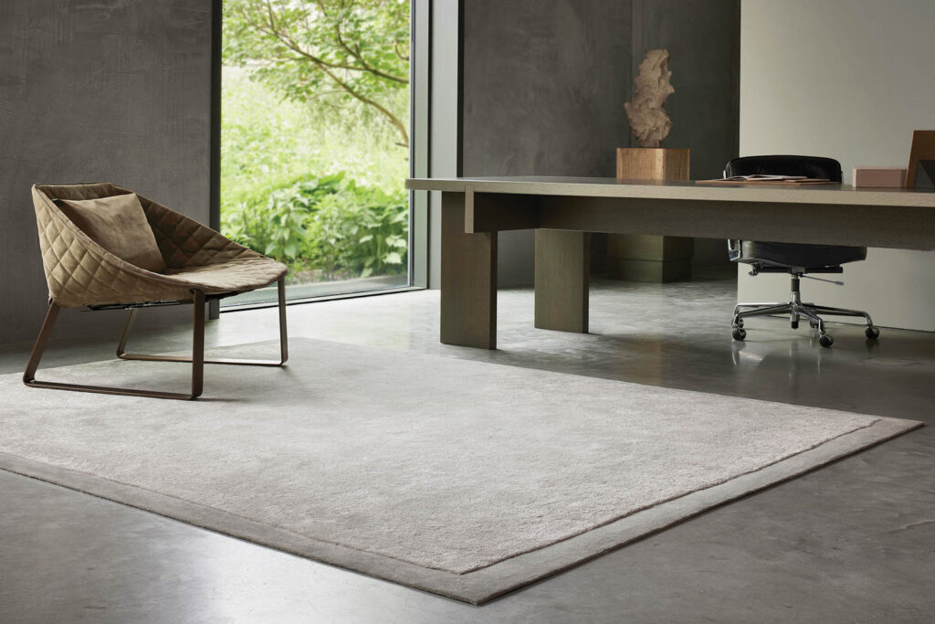 an office interior with a gray carpet and an armchair