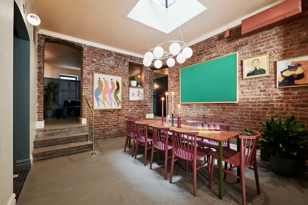 a private room with a long table and chandelier